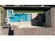 An aerial view of a backyard oasis featuring a pristine pool, spa, and cozy lounge area under a canopy at 3369 Ponicelli Ln, Henderson, NV 89044