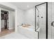 Elegant bathroom showcasing a luxurious tub, a glass-enclosed shower, and marble tiling for a spa-like retreat at 3369 Ponicelli Ln, Henderson, NV 89044