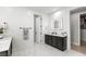 Modern bathroom featuring a black vanity with marble floors and an illuminated mirror, offering a sleek design at 3369 Ponicelli Ln, Henderson, NV 89044