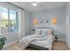 Stylish bedroom featuring wood floors, a cozy bed, and natural light from the window at 3369 Ponicelli Ln, Henderson, NV 89044