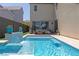 Inviting swimming pool with tiled waterfall feature and cozy patio furniture, perfect for outdoor relaxation at 3369 Ponicelli Ln, Henderson, NV 89044