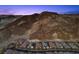 Beautiful new construction homes line a winding road, nestled against a scenic mountain backdrop at 34 Costa Tropical Dr, Henderson, NV 89011