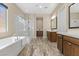 Elegant bathroom featuring a soaking tub, glass shower, and double vanities with ample storage space at 34 Costa Tropical Dr, Henderson, NV 89011