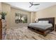 Spacious bedroom boasts decorative flooring, a ceiling fan, and a large window with verdant backyard views at 34 Costa Tropical Dr, Henderson, NV 89011