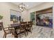 Elegant dining room with a stylish chandelier, hardwood floors, and sliding glass doors that lead to the outdoor patio at 34 Costa Tropical Dr, Henderson, NV 89011