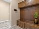 Functional mudroom with custom wood cabinetry, bench, and stylish wood-look tile flooring at 34 Costa Tropical Dr, Henderson, NV 89011