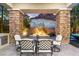Outdoor patio featuring a dining table, stone pillars, and views of desert landscaping for serene entertaining at 34 Costa Tropical Dr, Henderson, NV 89011