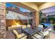 Covered patio boasts a stone fireplace, mountain views, and an outdoor dining area, perfect for entertaining guests at 34 Costa Tropical Dr, Henderson, NV 89011