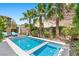 Backyard features a modern pool with a spa and beautiful landscaping, including mature palm trees and a privacy wall at 34 Costa Tropical Dr, Henderson, NV 89011
