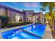 The rear of this home reveals an inviting pool with a spa, accompanied by elegant landscaping and a manicured lawn at 34 Costa Tropical Dr, Henderson, NV 89011