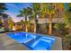 Inviting pool area surrounded by lush landscaping and featuring tranquil ambiance under palm trees against a sunset backdrop at 34 Costa Tropical Dr, Henderson, NV 89011
