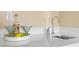Close up of a modern wet bar featuring a stylish faucet, white countertops, and designer glassware and lemons at 34 Costa Tropical Dr, Henderson, NV 89011