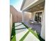 Backyard features artificial grass and patio with string lights and sliding door for indoor/outdoor living at 3447 Sw Covilha Ln, Henderson, NV 89044