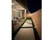 A well-manicured backyard features an artificial lawn, pavers, and cozy patio with string lights at 3447 Sw Covilha Ln, Henderson, NV 89044