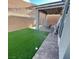 The backyard has artificial grass and a covered patio with brick pavers, perfect for relaxing at 3447 Sw Covilha Ln, Henderson, NV 89044
