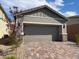 Home exterior with a two car garage and a brick driveway at 3447 Sw Covilha Ln, Henderson, NV 89044