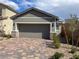 Home exterior with a two car garage and a brick driveway at 3447 Sw Covilha Ln, Henderson, NV 89044