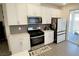 Modern kitchen featuring stainless steel appliances, white cabinetry, and a gray tiled backsplash at 3447 Sw Covilha Ln, Henderson, NV 89044