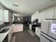 Open kitchen featuring white cabinets, modern appliances, and island seating at 3447 Sw Covilha Ln, Henderson, NV 89044
