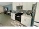 Well-lit kitchen with stainless steel oven, microwave, white cabinets, and gray backsplash, adjoining a living area at 3447 Sw Covilha Ln, Henderson, NV 89044