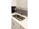 Close up on a stainless steel sink and white quartz countertops in a bright and modern kitchen at 3447 Sw Covilha Ln, Henderson, NV 89044
