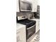 Modern kitchen featuring stainless steel appliances, white cabinetry, and gray tiled backsplash at 3447 Sw Covilha Ln, Henderson, NV 89044