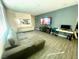 Open-concept living room with stylish gray sofa and TV wall at 3447 Sw Covilha Ln, Henderson, NV 89044