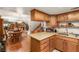 Eat in kitchen featuring wooden cabinets and light countertops is adjacent to a dining and living space at 3471 One Nation Ave, Las Vegas, NV 89121