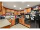 Kitchen featuring wooden cabinets, black appliances, light countertops, and tile flooring at 3471 One Nation Ave, Las Vegas, NV 89121