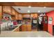 Kitchen featuring wooden cabinets, black appliances, light countertops, and tile flooring at 3471 One Nation Ave, Las Vegas, NV 89121