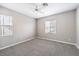 A simplistic bedroom with gray carpet, two windows, and neutral walls at 3725 Moonshine Falls Ave, North Las Vegas, NV 89085