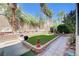 Backyard featuring lush green lawn, mature landscaping, privacy wall and sidewalk to a patio at 3873 Palm Island Ct, Las Vegas, NV 89147