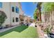 Enjoy a landscaped backyard with synthetic grass, covered patio and easy access to the interior at 3873 Palm Island Ct, Las Vegas, NV 89147