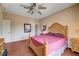 Comfortable bedroom with a decorative headboard, ceiling fan, and wood-look floors at 3873 Palm Island Ct, Las Vegas, NV 89147
