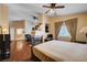 Open bedroom with fireplace, ceiling fan, and view into bathroom at 3873 Palm Island Ct, Las Vegas, NV 89147