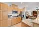 Bright kitchen with stainless steel refrigerator, tile floors, granite countertops, and wood cabinets at 3873 Palm Island Ct, Las Vegas, NV 89147