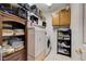 Bright laundry room with stacked washer/dryer and ample storage shelves at 3873 Palm Island Ct, Las Vegas, NV 89147