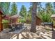 Inviting back deck area featuring an outdoor dining set, grill, and built-in tree at 3935 White Fir Way, Mount Charleston, NV 89124