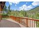 Large wooden deck with mountain views, a wooden safety rail, and access to the home's backyard at 3935 White Fir Way, Mount Charleston, NV 89124