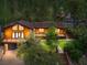 Charming wooded home featuring a large deck, brown metal roof, and an attached garage at 3935 White Fir Way, Mount Charleston, NV 89124