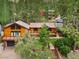 Charming wooded home featuring a large deck, brown metal roof, and an attached garage at 3935 White Fir Way, Mount Charleston, NV 89124
