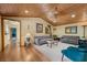 A cozy living room with grey couches, a wooden ceiling, and hardwood floors at 3935 White Fir Way, Mount Charleston, NV 89124