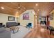 A well-lit living room featuring wood paneling, comfortable seating, and an open layout at 3935 White Fir Way, Mount Charleston, NV 89124
