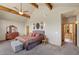 Large main bedroom featuring exposed beams, ensuite access, scenic views, and a cozy sitting area at 3935 White Fir Way, Mount Charleston, NV 89124