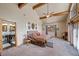 Bright main bedroom with exposed wood beams, ensuite bath, comfortable carpet and access to outdoor patio at 3935 White Fir Way, Mount Charleston, NV 89124