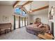 Spacious main bedroom with a vaulted ceiling, exposed wood beams, and mountain views from the large windows at 3935 White Fir Way, Mount Charleston, NV 89124