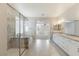 Well-lit bathroom showcasing a glass-enclosed shower, soaking tub, double vanity, and tiled flooring at 425 Canary Song Dr, Henderson, NV 89011