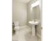 Clean and modern powder room featuring a pedestal sink, a toilet, and neutral color palette at 425 Canary Song Dr, Henderson, NV 89011