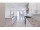 Open-concept kitchen with granite countertops, white cabinets and stainless steel appliances flowing into the living area at 425 Canary Song Dr, Henderson, NV 89011