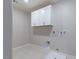 Functional laundry room with white cabinetry, utility connections, and tile flooring at 425 Canary Song Dr, Henderson, NV 89011